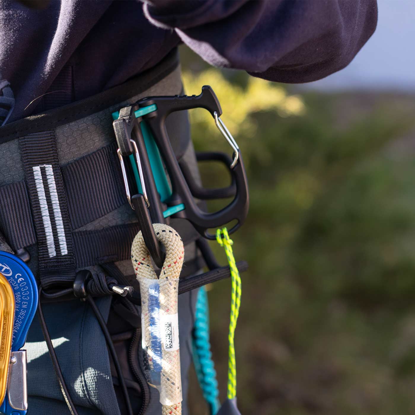 Cargo Tool Carrier tool carrier in black and green attached to the climbing harness with ropes