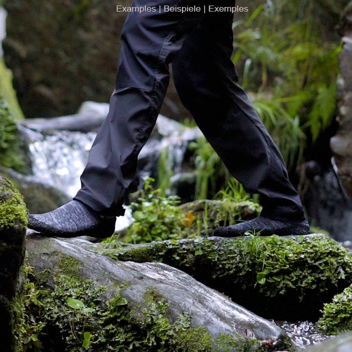 Skinner's gray sock with black sole on a foot standing on a moss-covered stone in nature