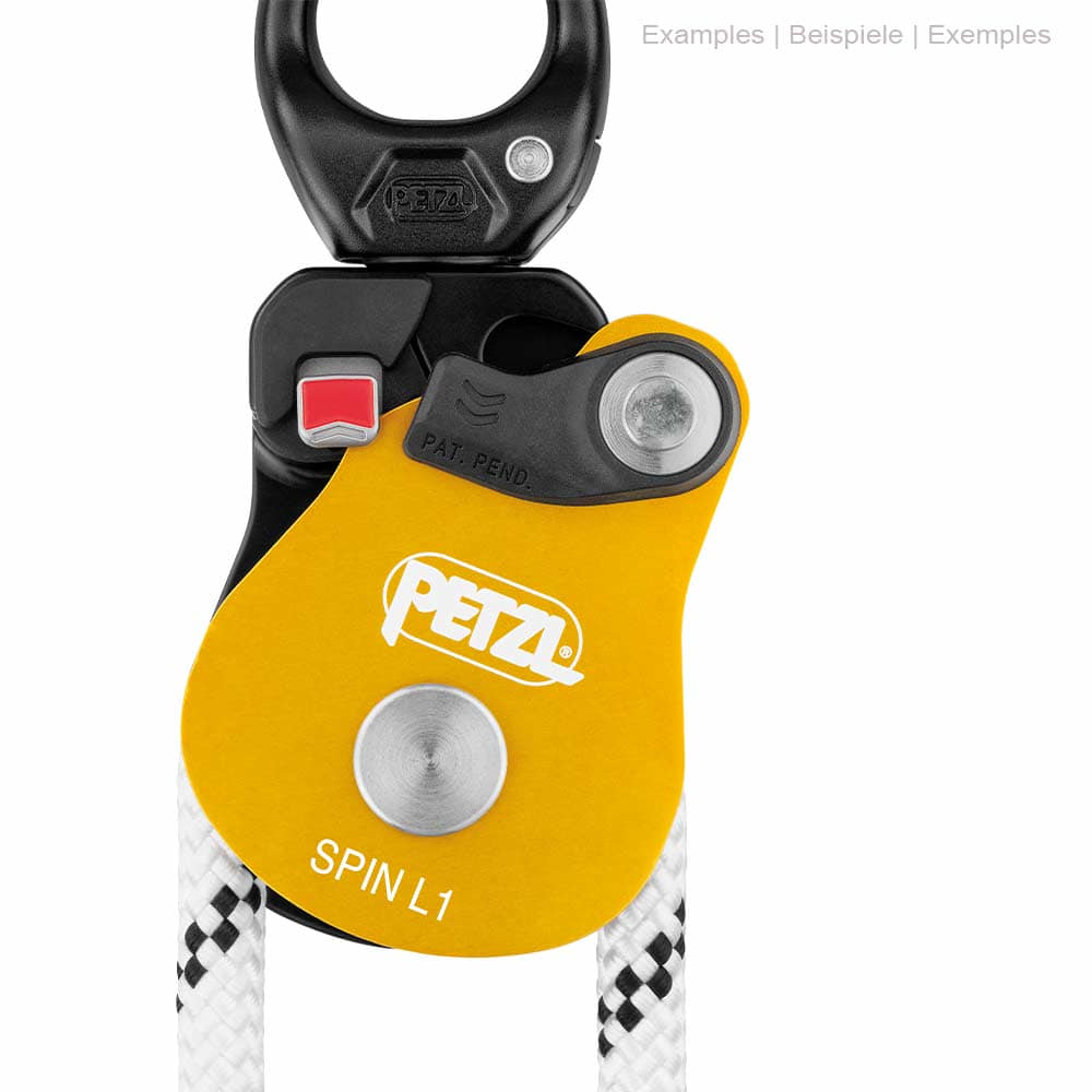 Close-up of the Petzl Spin L1 pulley with yellow housing, black upper part and white rope, red button and Petzl logo