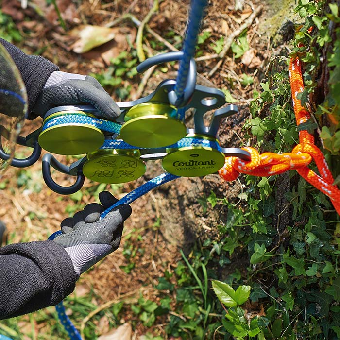 Hulk product with green round elements and black metal frame, connected with blue and orange ropes, is held by a person wearing gloves