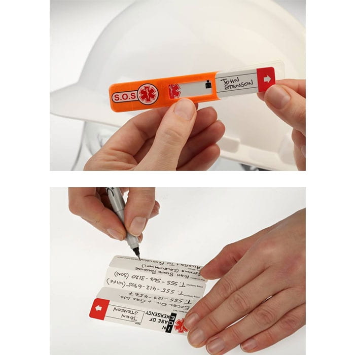 Vital ID Emergency ID orange with red arrow and text "S.O.S" and "IN CASE OF EMERGENCY", held by two hands, one hand writes "John Stenson"