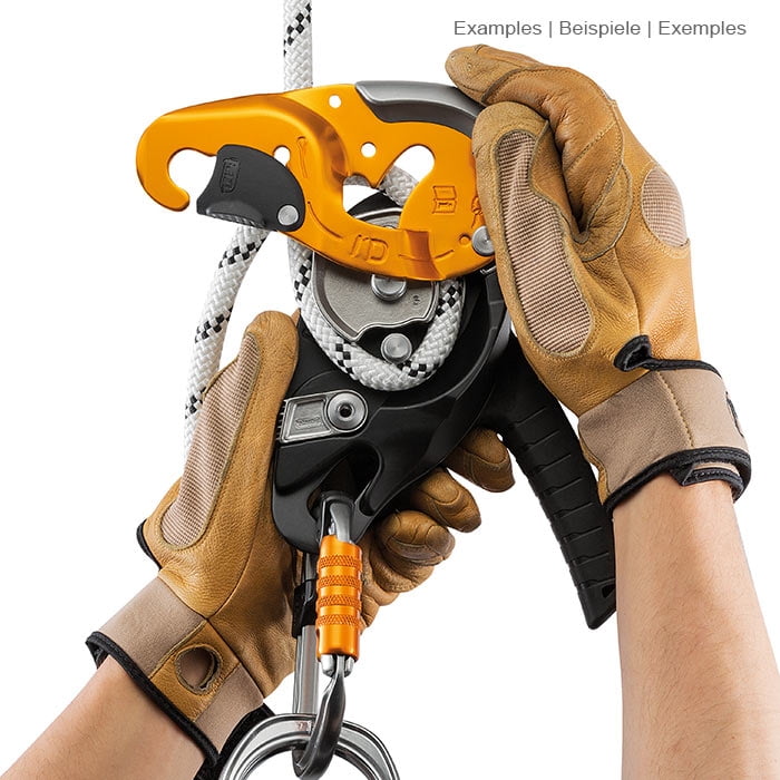 Hands in brown work gloves operate the yellow and black climbing equipment I'D S from Petzl with white rope