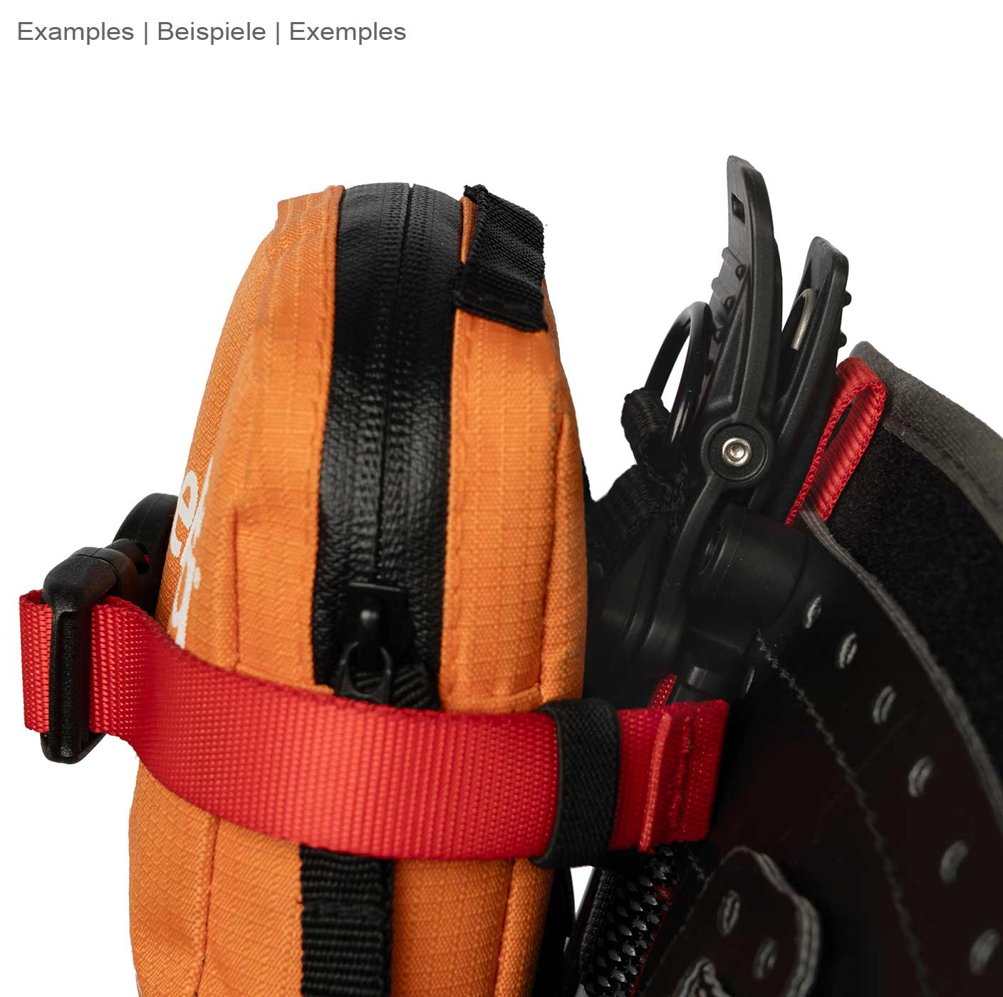 Caiman by DMM, red ribbon attached to an orange zippered bag with black Velcro closure