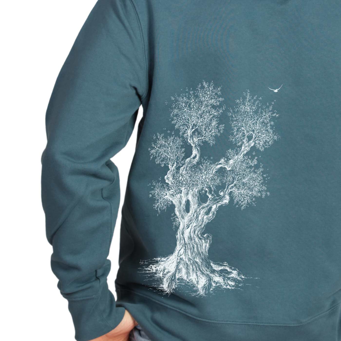 Olive Tree Hoodie in teal, detail of the white tree print on the back, carried by a person with hand in his trouser pocket