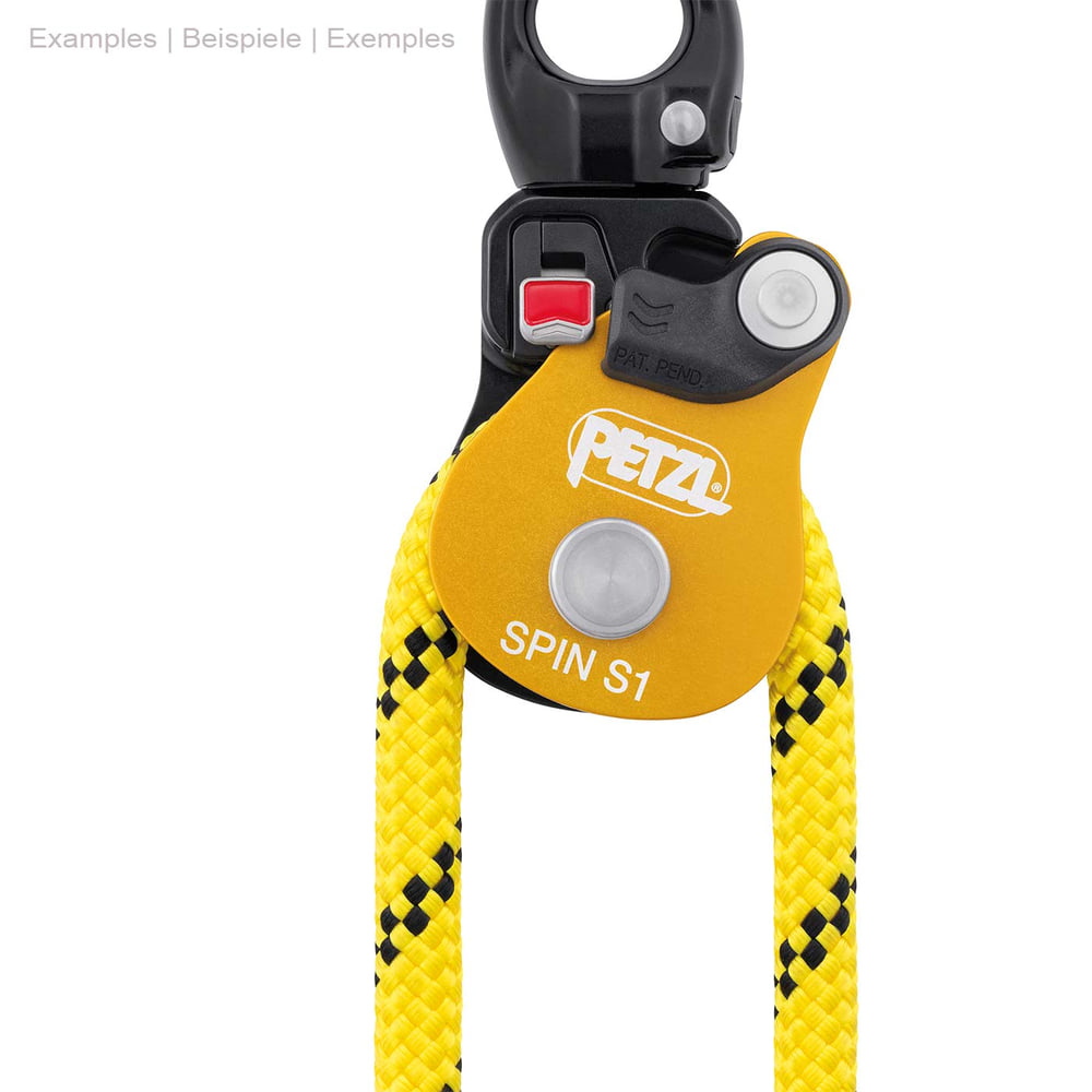 Petzl Spin S1, yellow-black pulley with metal ring on top and yellow rope pulled through, red button visible on black part