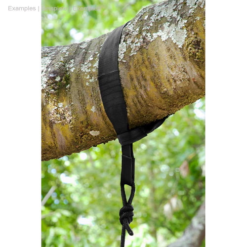 Black TreeMount Seat strap tied around a tree trunk with string and knot, green leaves visible in the background