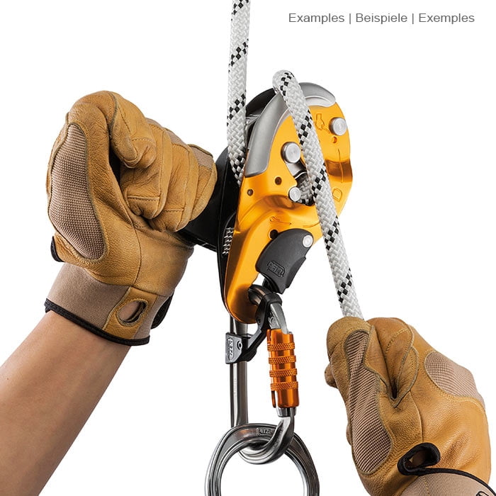 Hands in brown work gloves operate the climbing equipment I'D S by Petzl with white rope and carabiner