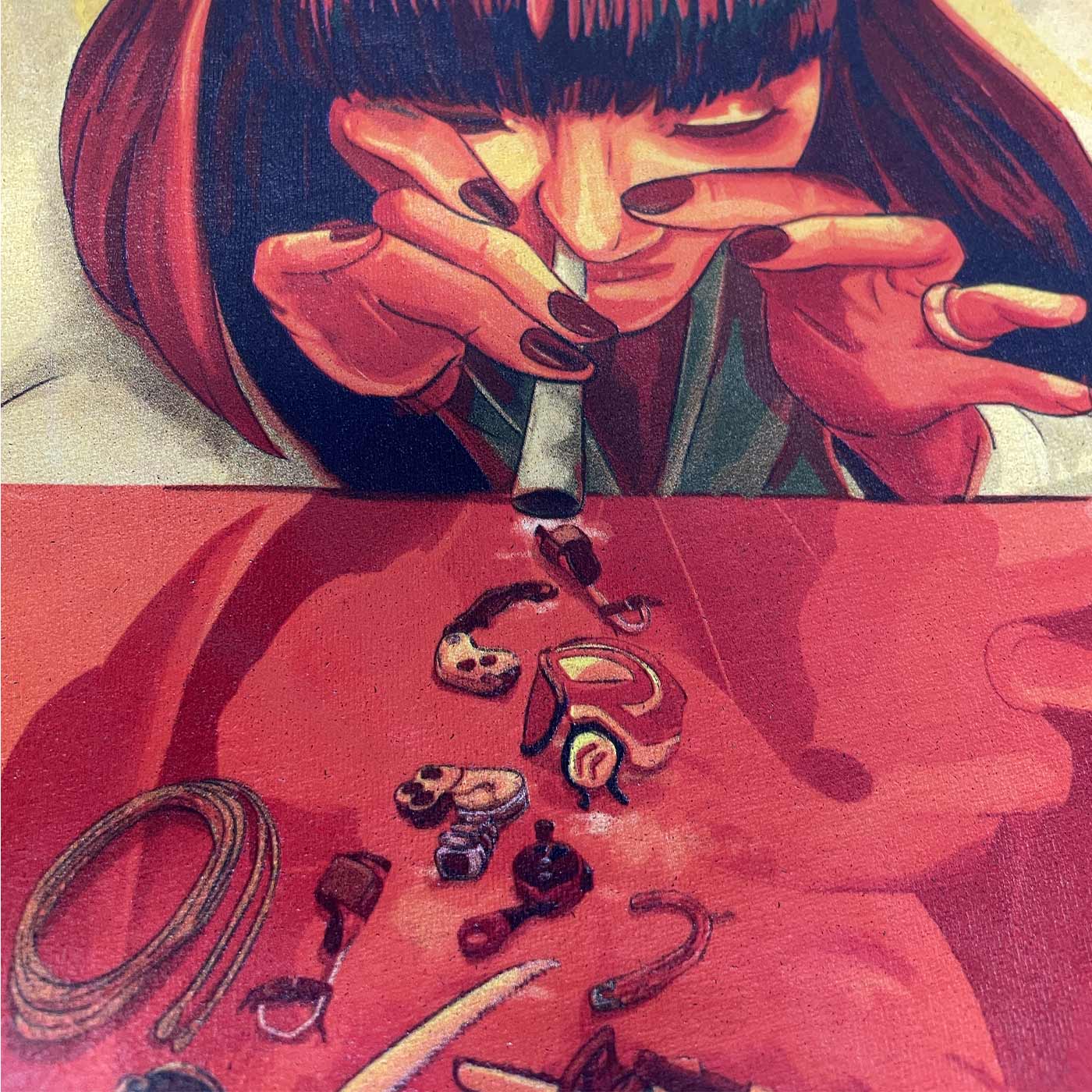 Close-up of colored front print on the Arb Addiction T-shirt with a woman looking across a table and looking at small objects
