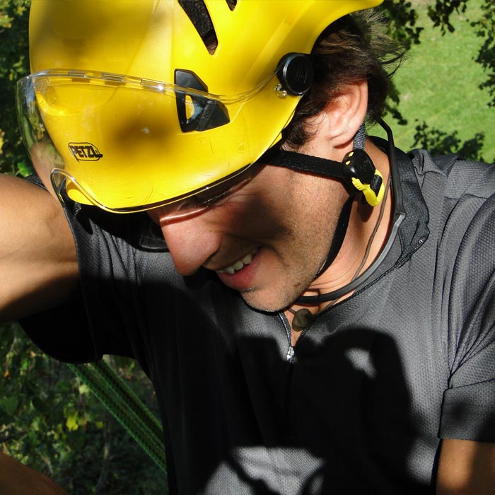 Man with yellow Petzl helmet and gray shirt wearing transparent goggles Vizir Shadow