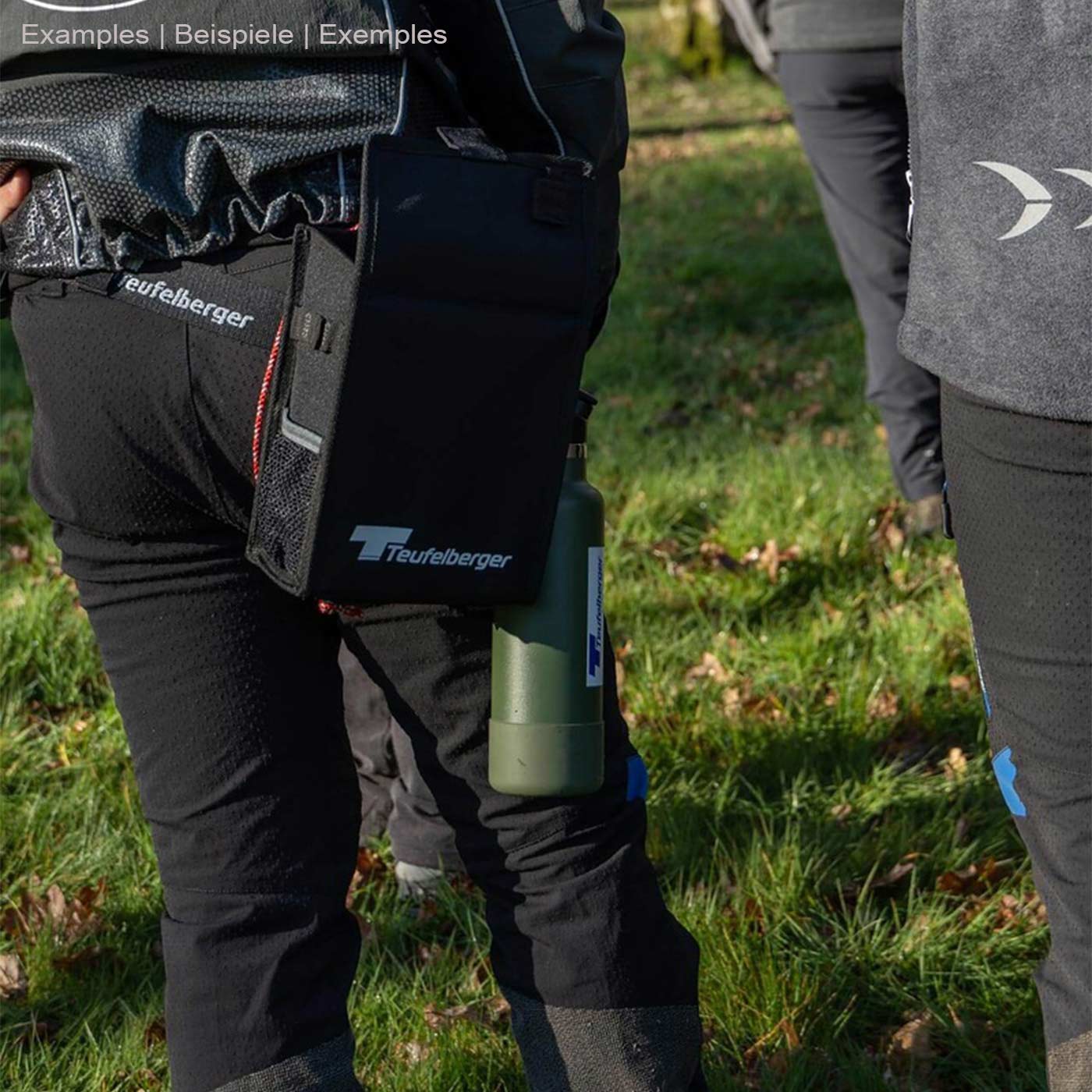 Mini Mule by Teufelberger, attached to a person's hip, black bag with Teufelberger logo, next to it a green bottle with Teufelberger logo