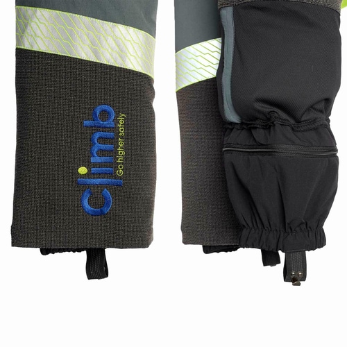 Detail of the lower legs of the Climb cut protection trousers with reflective stripe, embroidered "climb" logo in blue and yellow and elastic leg cuffs with hook closure