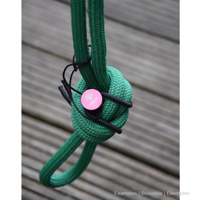 Rope Pin Set red pin on green rope with knots on wooden background