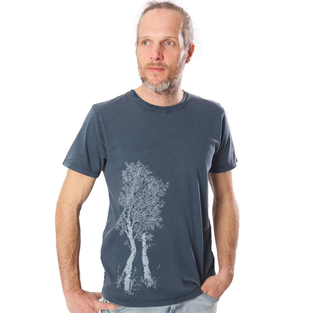 Man wearing a dark blue Birch Tree T-shirt with a white tree motif on the left front