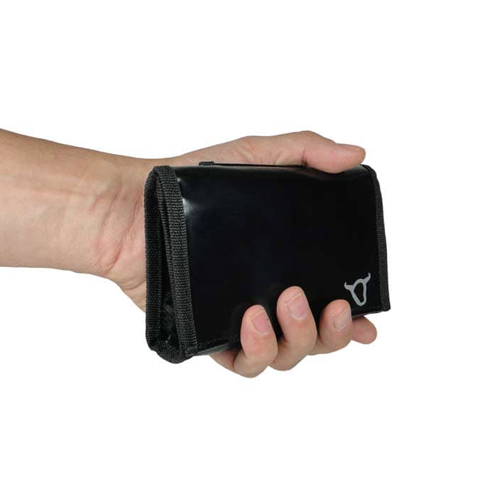 Black belt pouch with black rim and white bull's head logo, held in one hand
