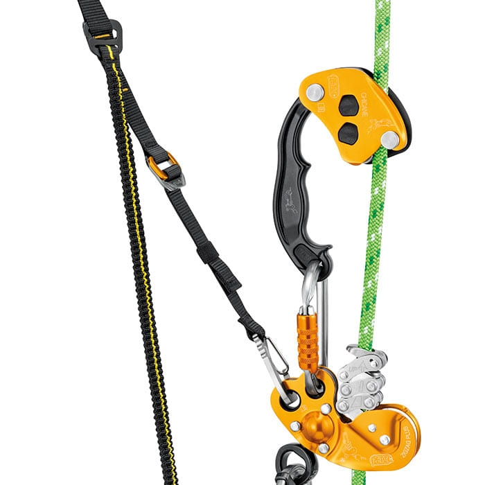 Close-up of the black and yellow Petzl climbing device with carabiner and green rope