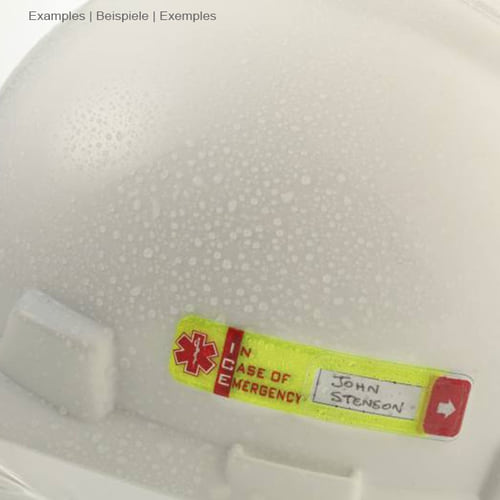 Vital ID Emergency ID yellow with red arrow and text "IN CASE OF EMERGENCY" with handwritten name "John Stenson" on a white helmet with water droplets, manufacturer Vital ID