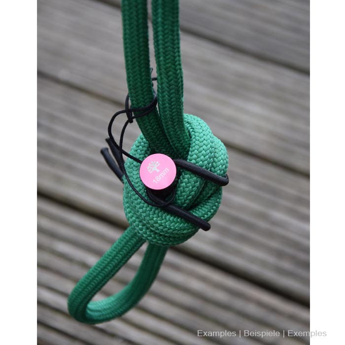 Rope Pin Set red pin on green rope with knots on wooden background