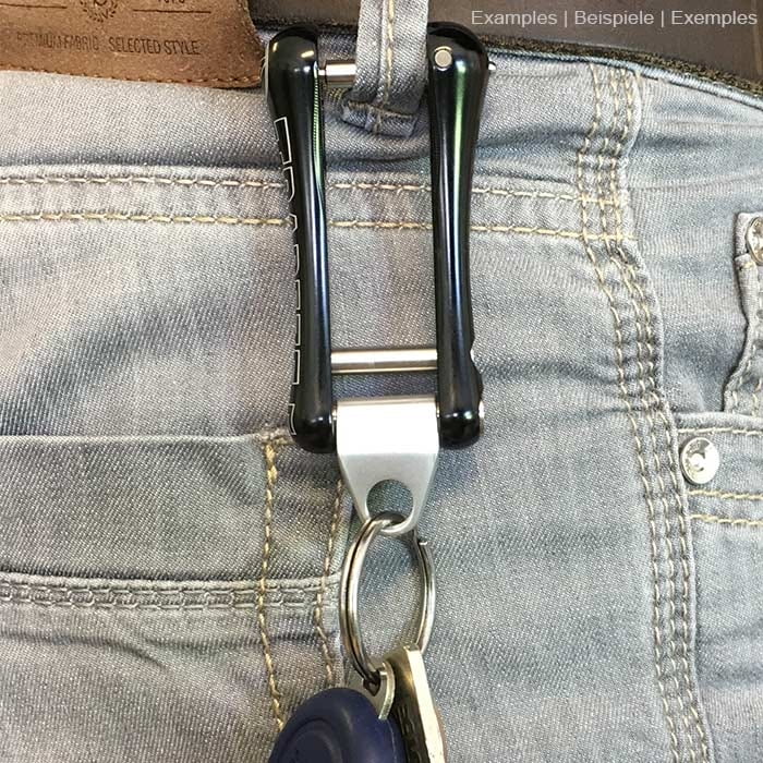 Trapezoid metal eye engraved with ART, attached to a black plastic trapezoid hanging from a belt with key ring and keys