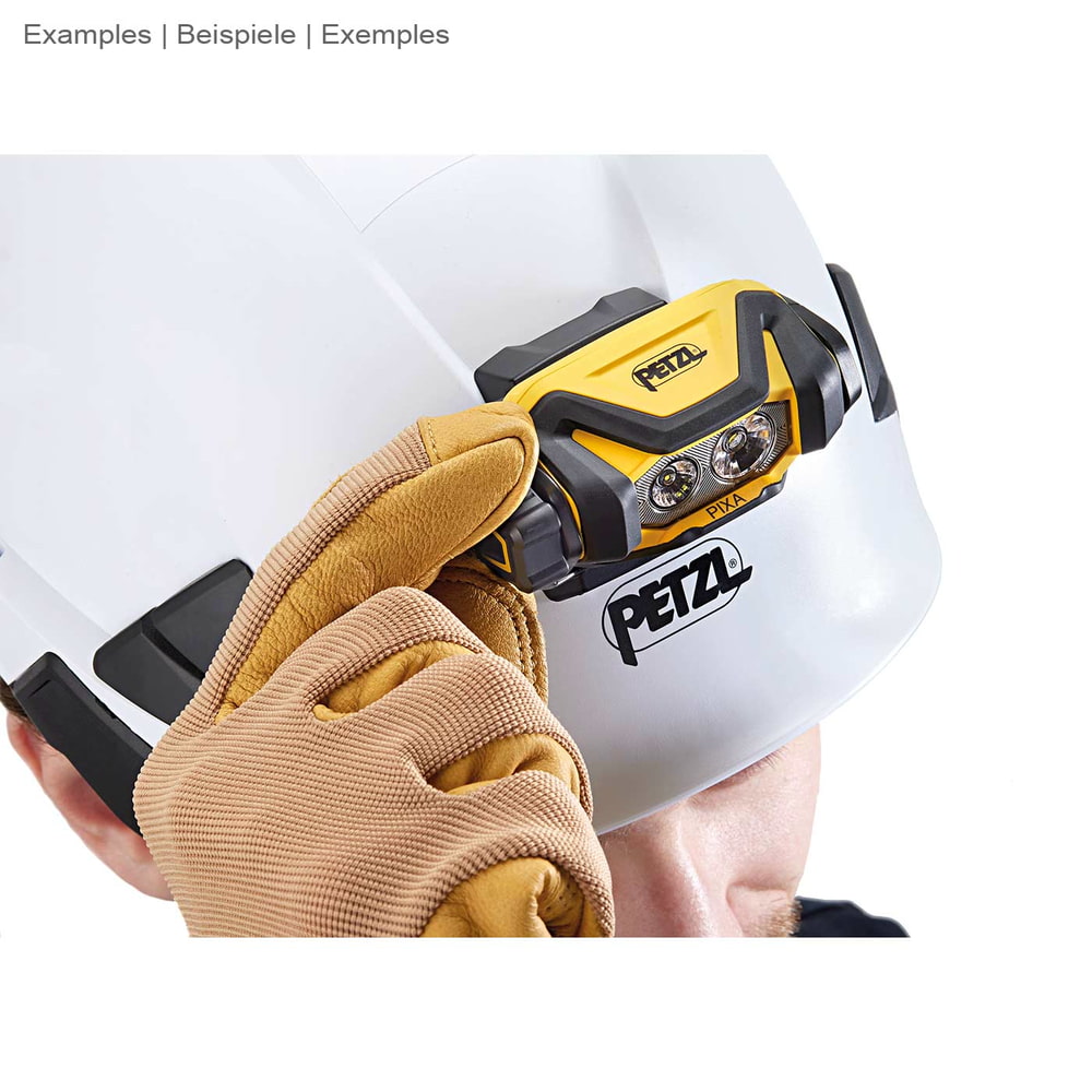Person in gloves holding Petzl Pixa headlamp on white safety helmet with Petzl logo