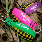 Throw Weight of Notch, three weight values in green (14oz), pink (12oz) and purple (10oz) lie on dry foliage and grass, each with a metallic ring
