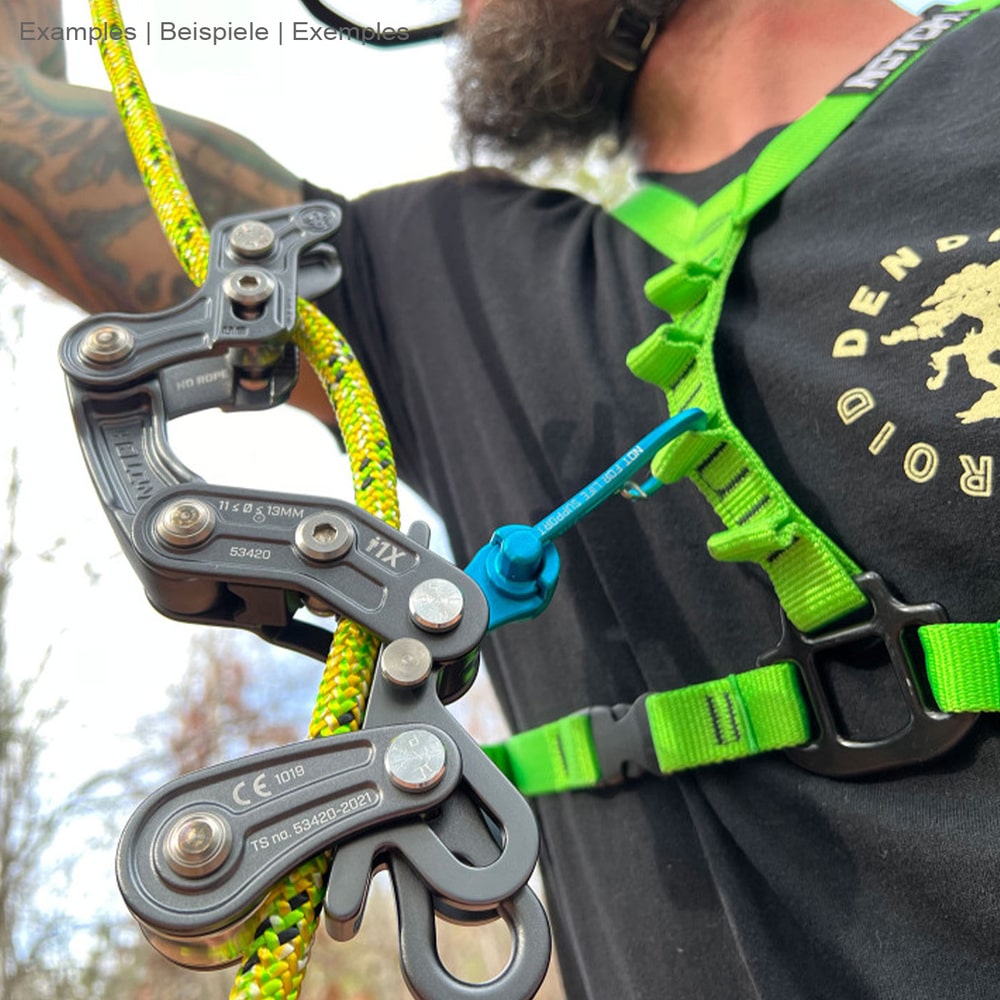 Person wearing a green harness and black T-shirt with a blue Magneato snap hook attached to it connected to a black climbing tool and yellow rope