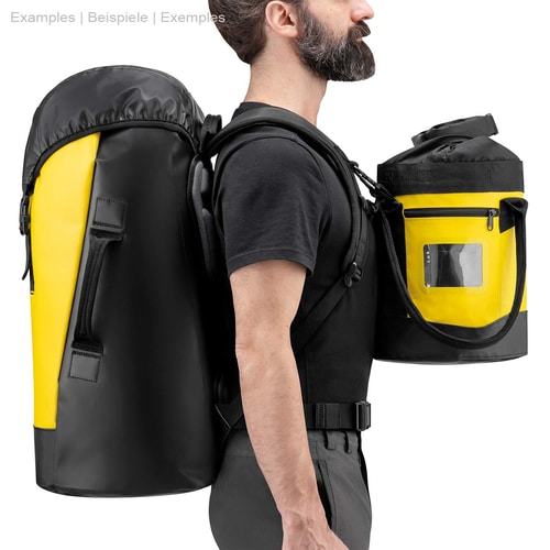 Man wearing Petzl Transport 45 backpack in yellow and black and holding a smaller yellow and black zippered pouch