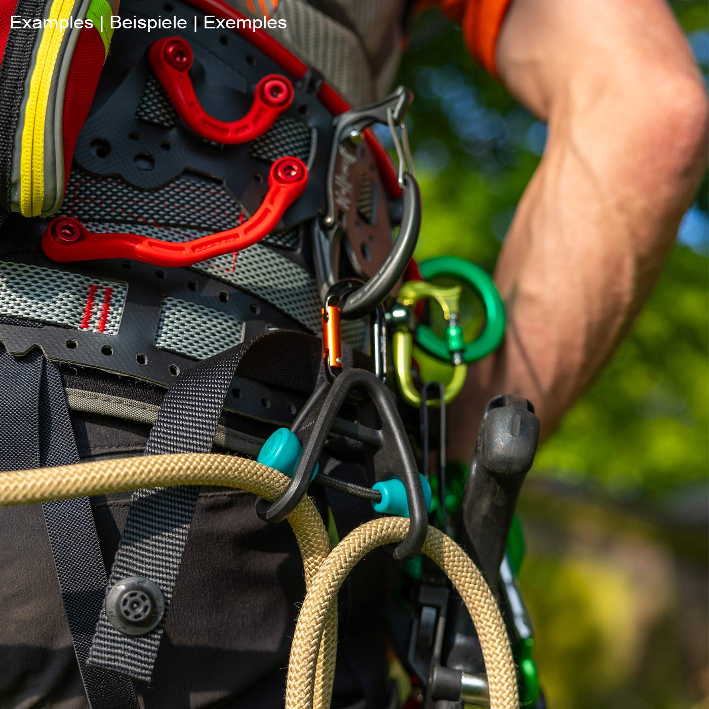 Sidekick product in black with two turquoise buttons, attached to a climbing harness with beige and yellow climbing line