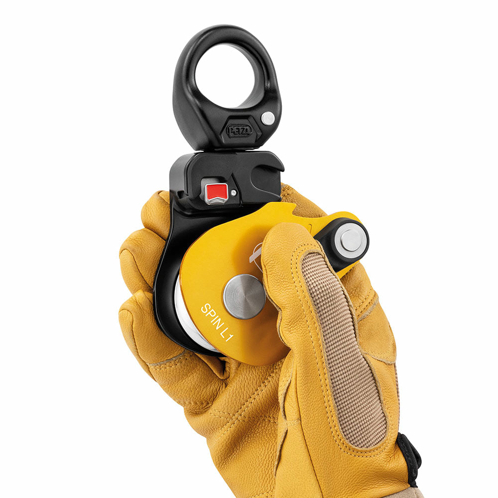 Petzl Spin L1 Rope Pulley with Yellow Housing, Held by One Hand with Yellow Work Glove