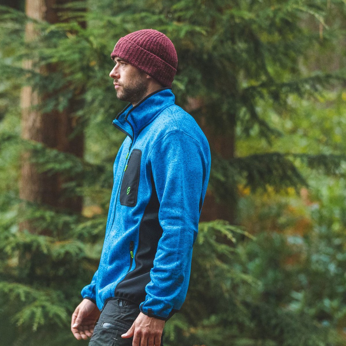 Man wearing blue kudu plus fleece jacket with black chest pocket in a forest