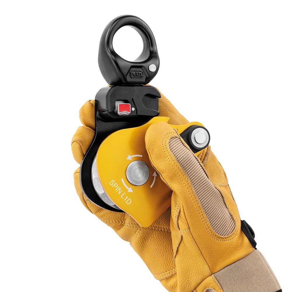 Petzl Spin L1D pulley with glove on one hand holding the pulley