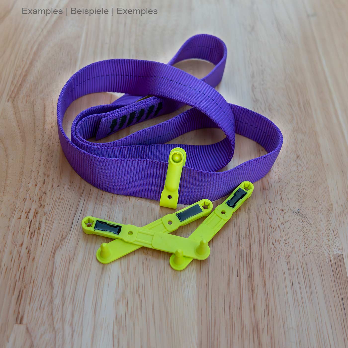 Three yellow loops NFC tag from Scannable lie on a wooden table next to a purple loop made of fabric