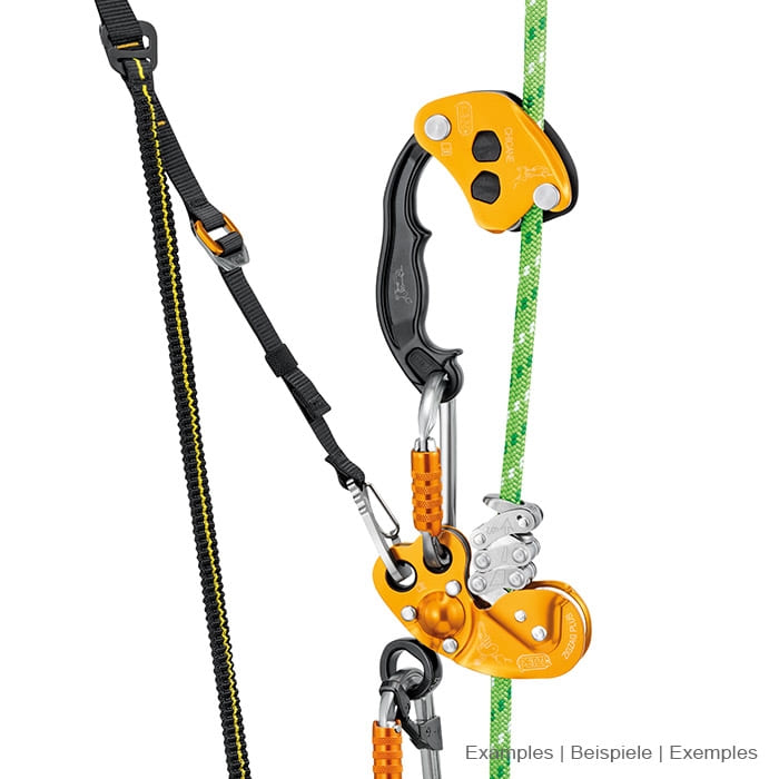 Petzl Chicane, yellow and black belay device with handle, connected to a carabiner and a black band on a green rope