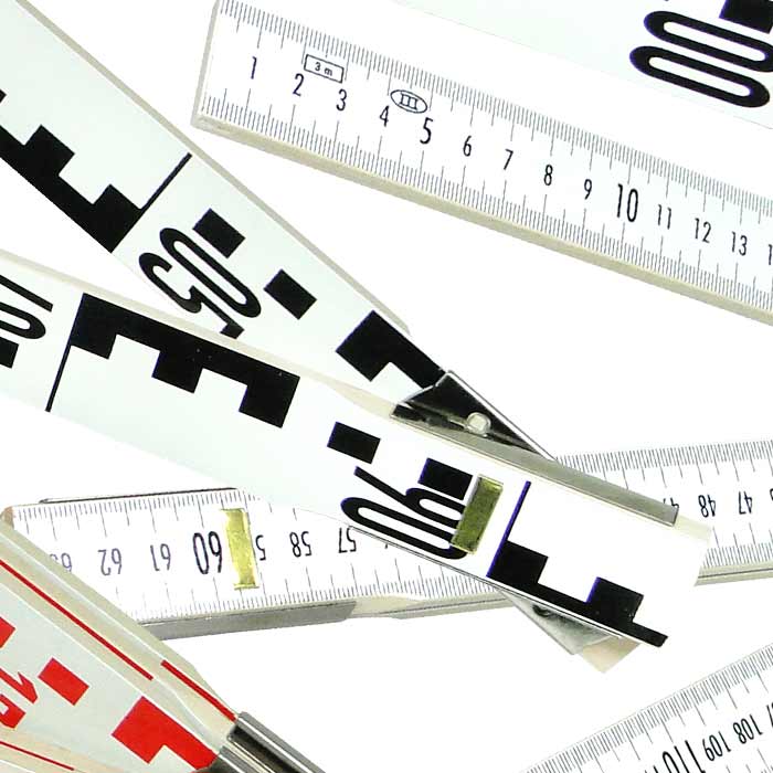 Geometer scale with white segments, black and red numbers and markings, close-up of joints and scales