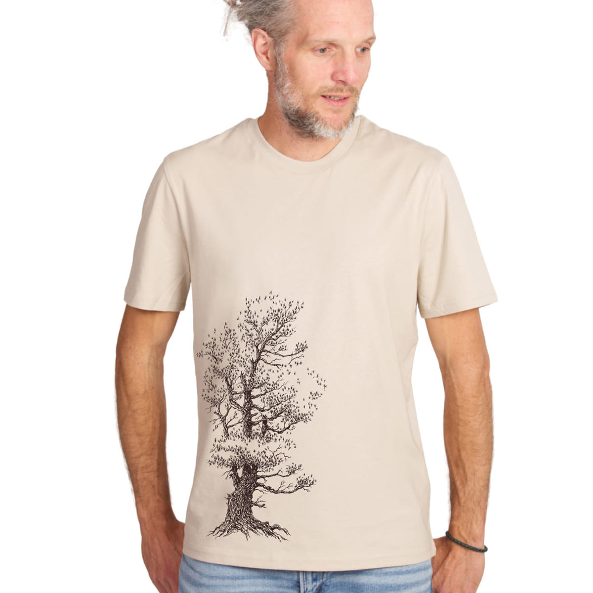 Man wearing Stone Pine Tree T-shirt in beige with black tree design, looking to the right