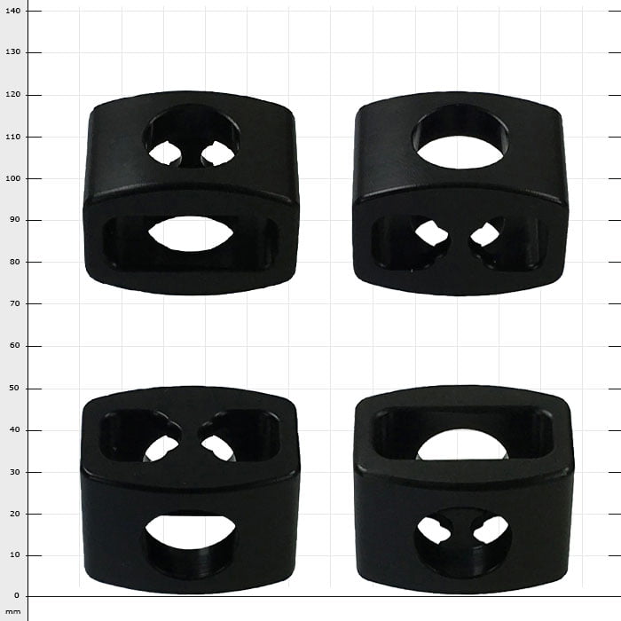 StopperGate black plastic parts with different holes, four pieces on white grid background
