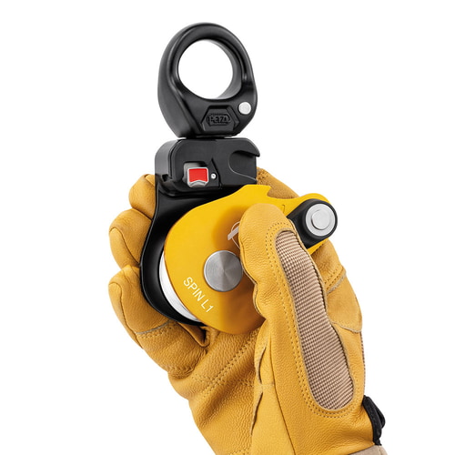 Petzl Spin L1 Rope Pulley with Yellow Housing, Held by One Hand with Yellow Work Glove