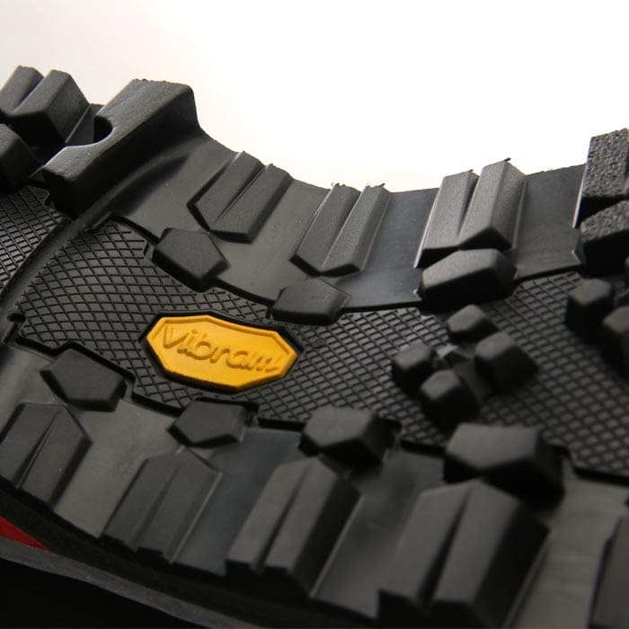 Close-up of black lugged sole with yellow Vibram logo