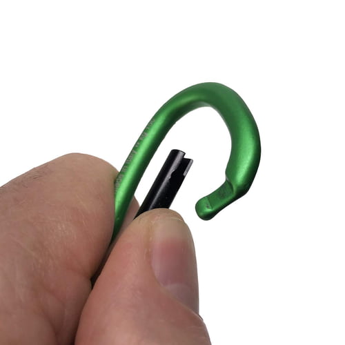 Green snap hook Big Mini with black closure mechanism, held by one hand against white background