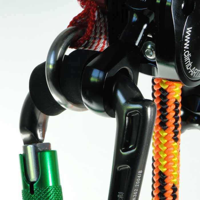Close-up of a black and green Rhino carabiner attached to a black metal part with colorful rope