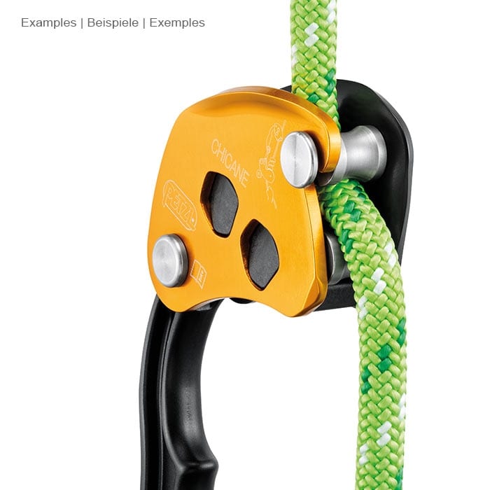 Petzl Chicane, yellow and black belay device with handle, on a green rope