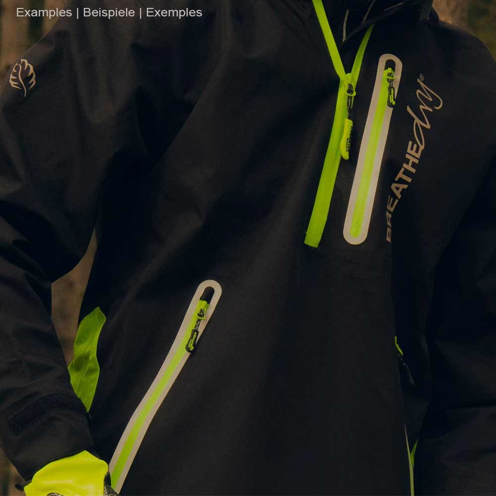 Close-up of a person wearing black BreatheDry smock jacket with green details and zippered pockets