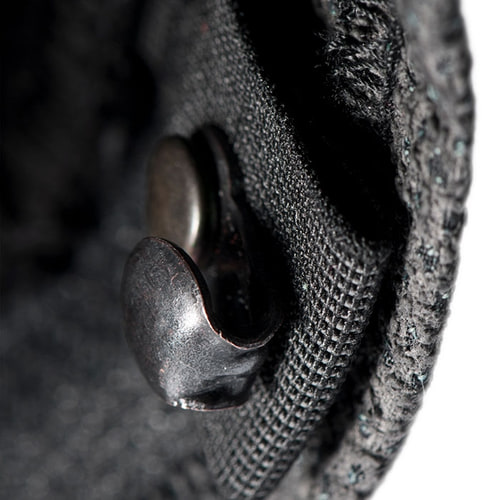 Close-up of a black metal button on a fabric, presumably part of the Arborist Progress pants