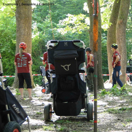 Beach Rolly Dolly Beach Cart in Blue and Black with a White Bull Head Logo on the Back, Standing in the Forest with Several People in the Background