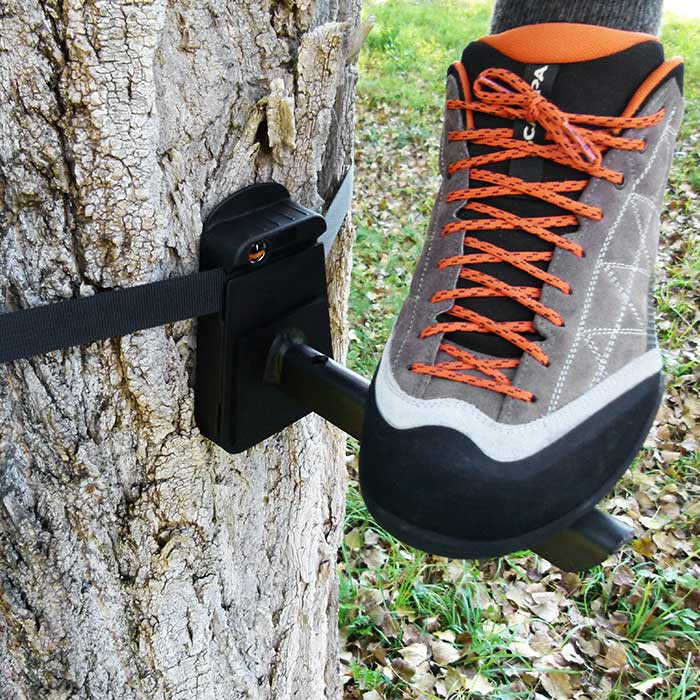 Tree-Monkey Steppers black metal base with black fastening block attached to tree trunk, grey shoe with orange laces on metal base
