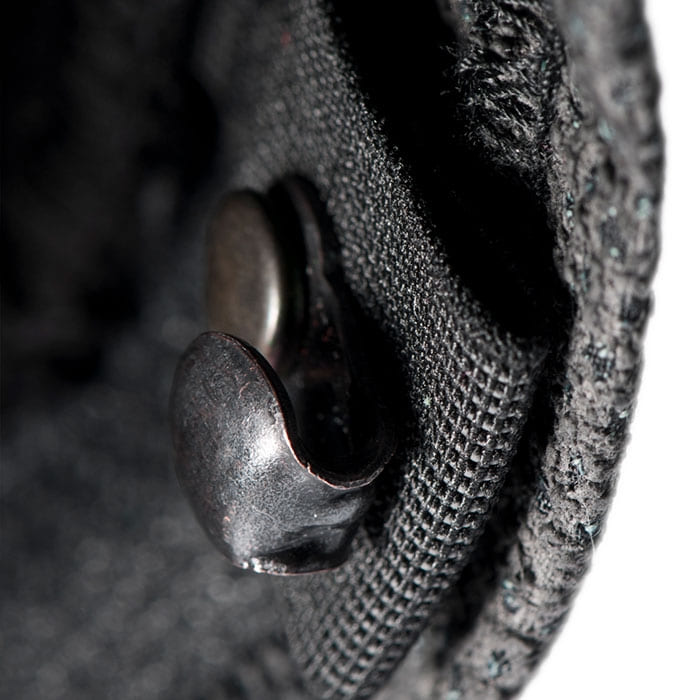 Close-up of a black metal button on a fabric, presumably part of the Arborist Progress pants