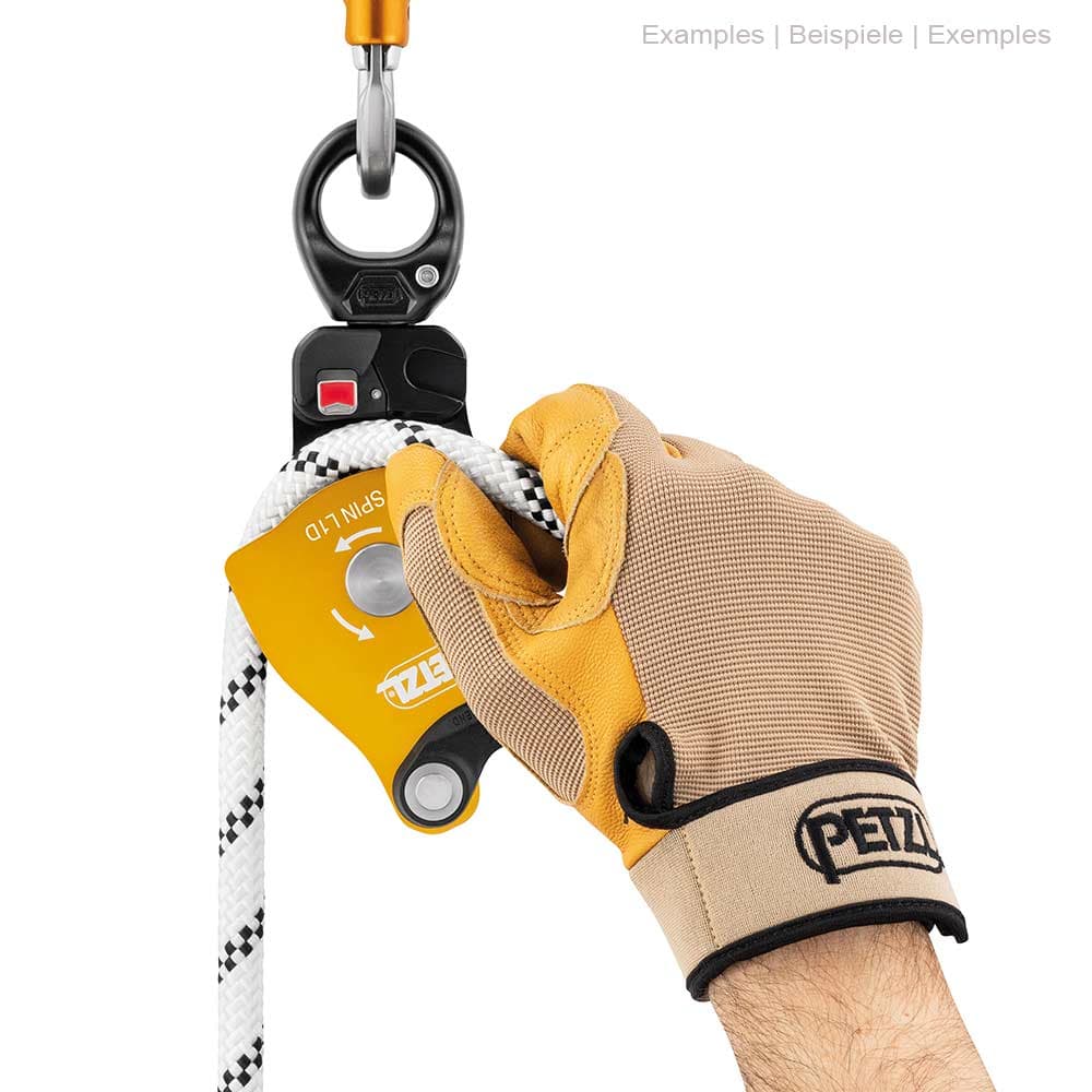 Petzl Spin L1D pulley with glove on one hand holding a white rope