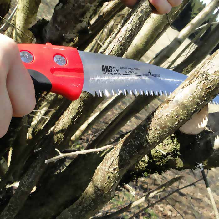 CTR-32 Pro saw from ARS in use, cuts a branch, visible serrated blade and red handle with screws and logo